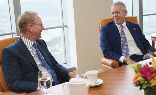 Craig Lindner and Carl Lindner III talking, seated at a conference table