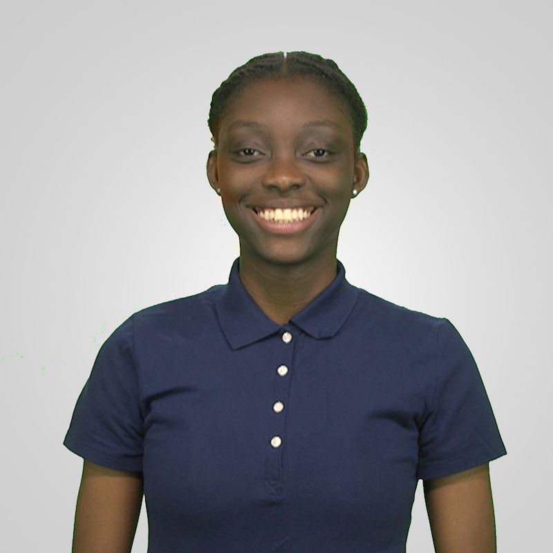 Headshot of Hailey Manual in a navy short sleeve polo in front of grey lit background